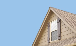 Roof gable with blue sky and window shutters